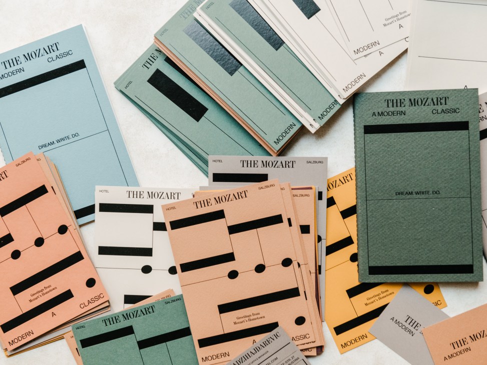 Scattered colorful brochures and cards for The Mozart hotel in Salzburg with geometric designs and black stripes