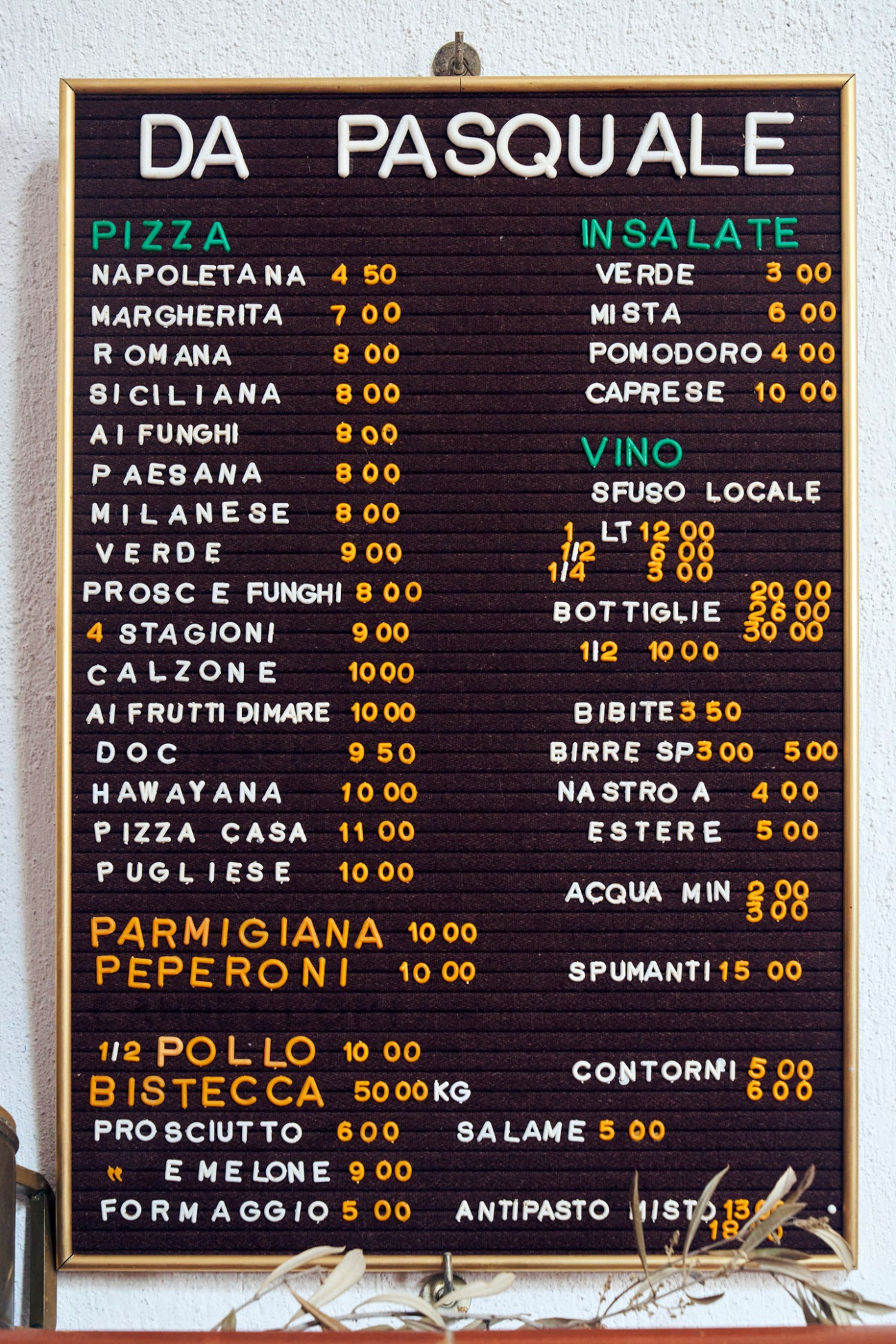 Menu board for Da Pasquale pizzeria showing Italian dishes and prices in euros
