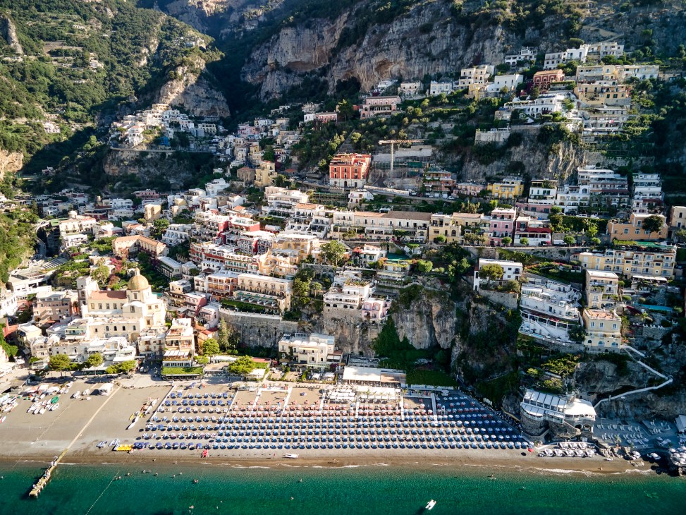 Dramatic cliffside view of Positano's colorful houses cascading down to the Mediterranean sea