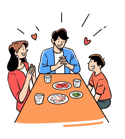 Family of three sitting around dinner table with food and drinks, appearing happy and celebratory