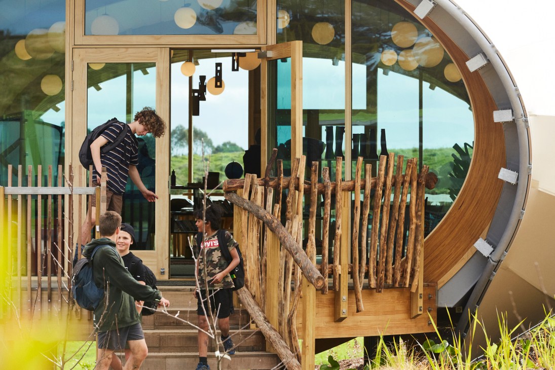 Children engaged in hands-on learning activities at Green School New Zealand with wooden playground equipment