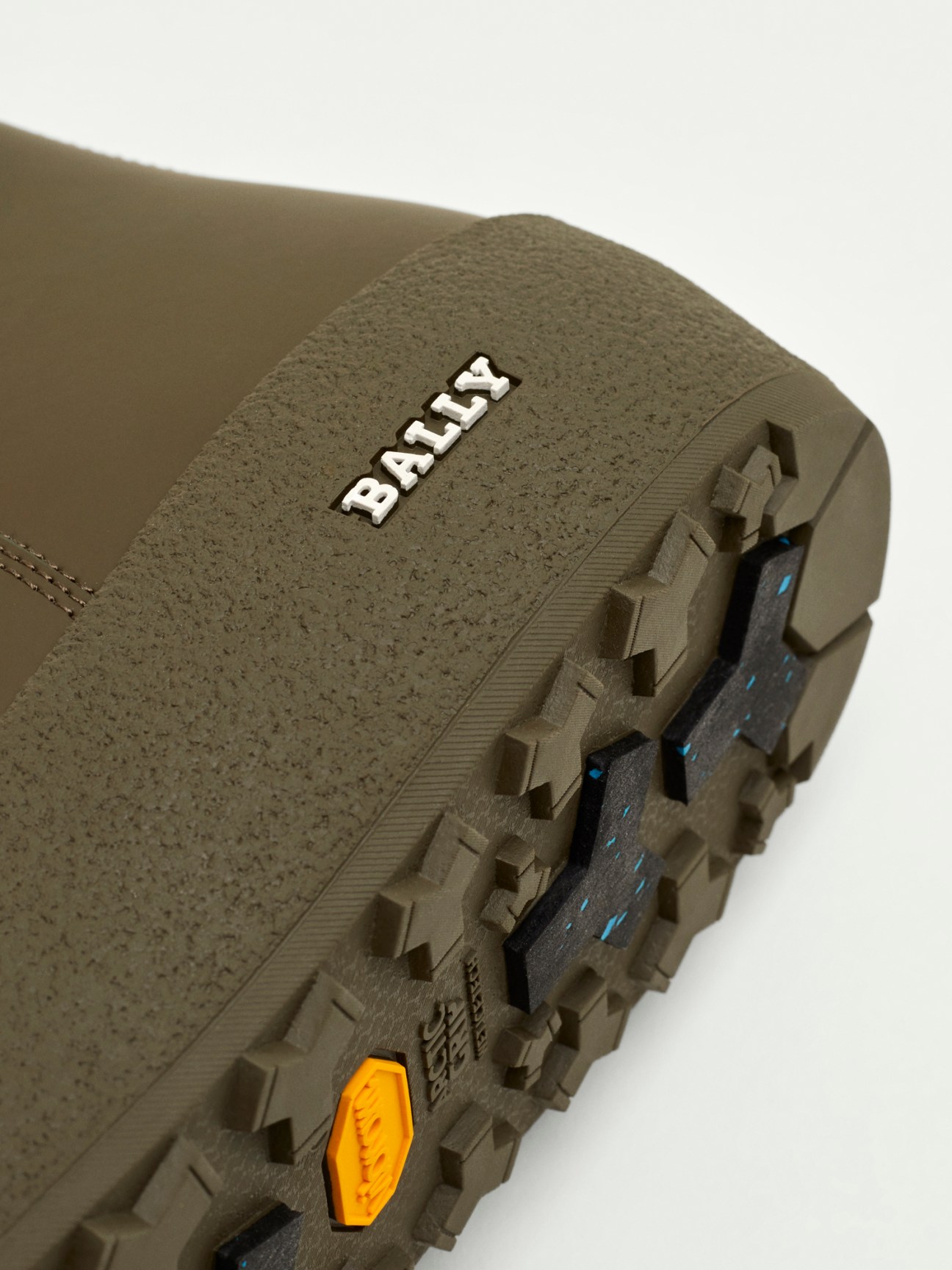 Close-up detail of olive green Bally curling boot sole showing Vibram treads and construction