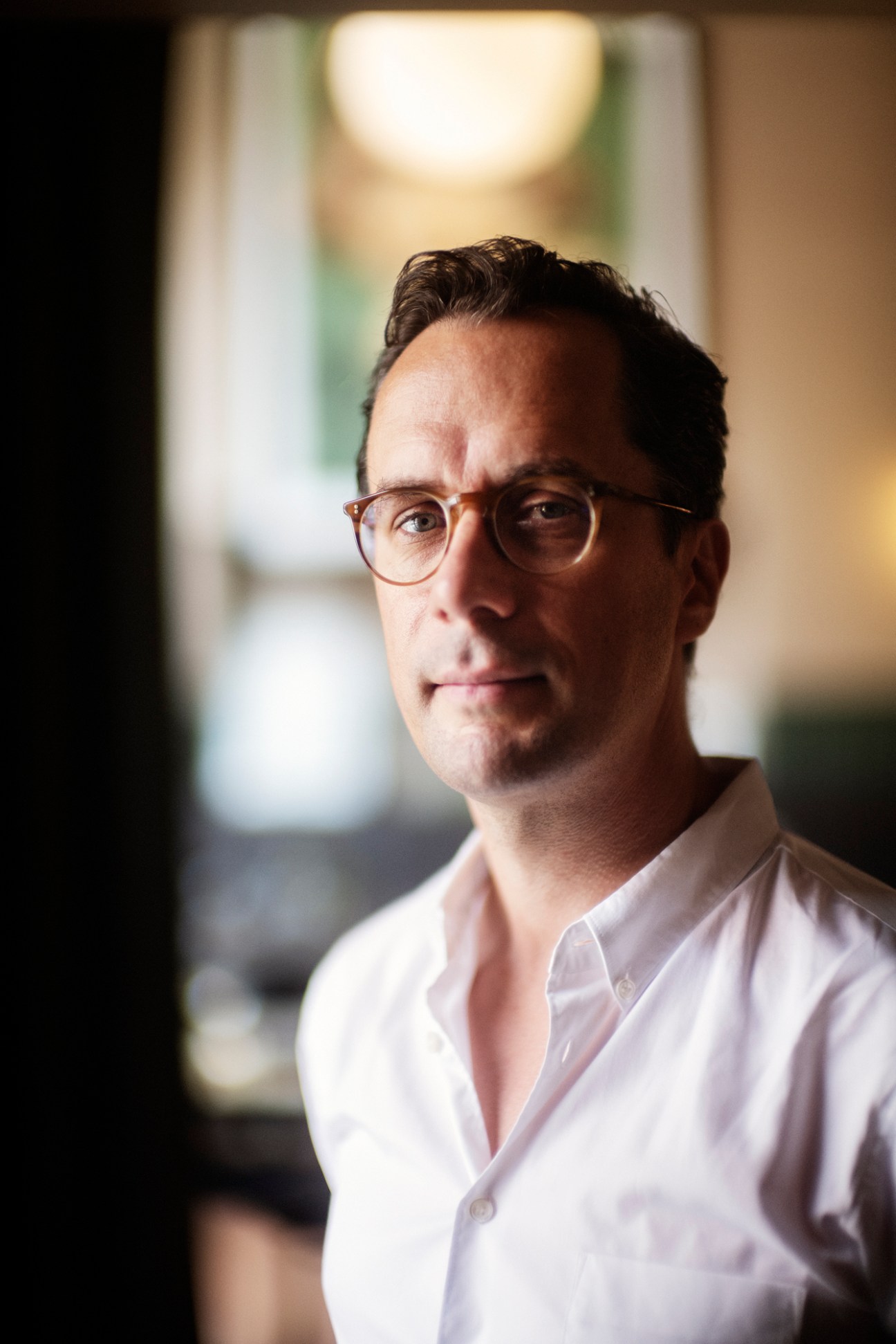 Jakob Abrahamsson, CEO of Capitol Bio, wearing glasses and a white shirt in an interior setting