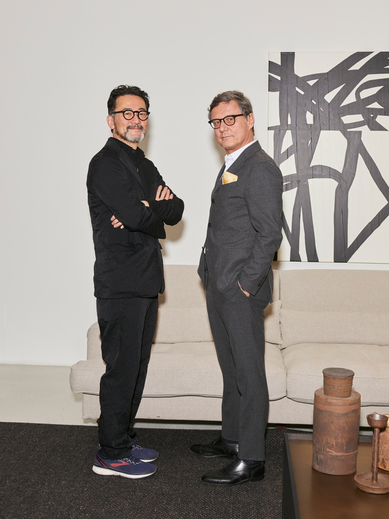 Roberto Gavazzi and Ryutaro Yoshida standing in a modern room with white sofa and abstract wall art