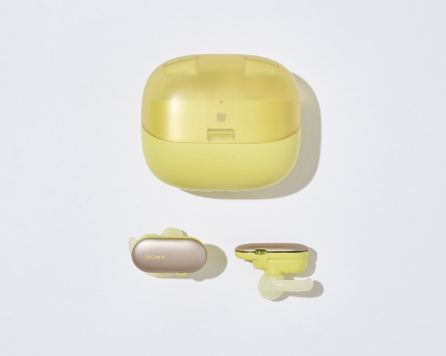 Sony yellow wireless earbuds with charging case on light background.