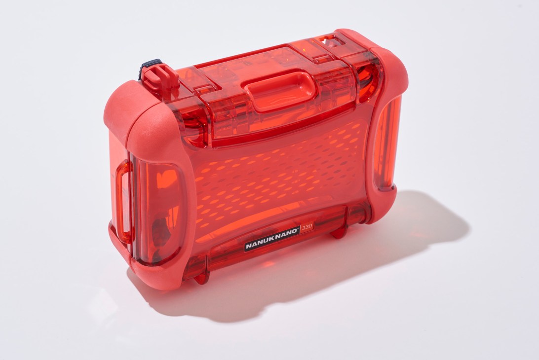 Red translucent Nanuk protective case with handles and latches on white background.