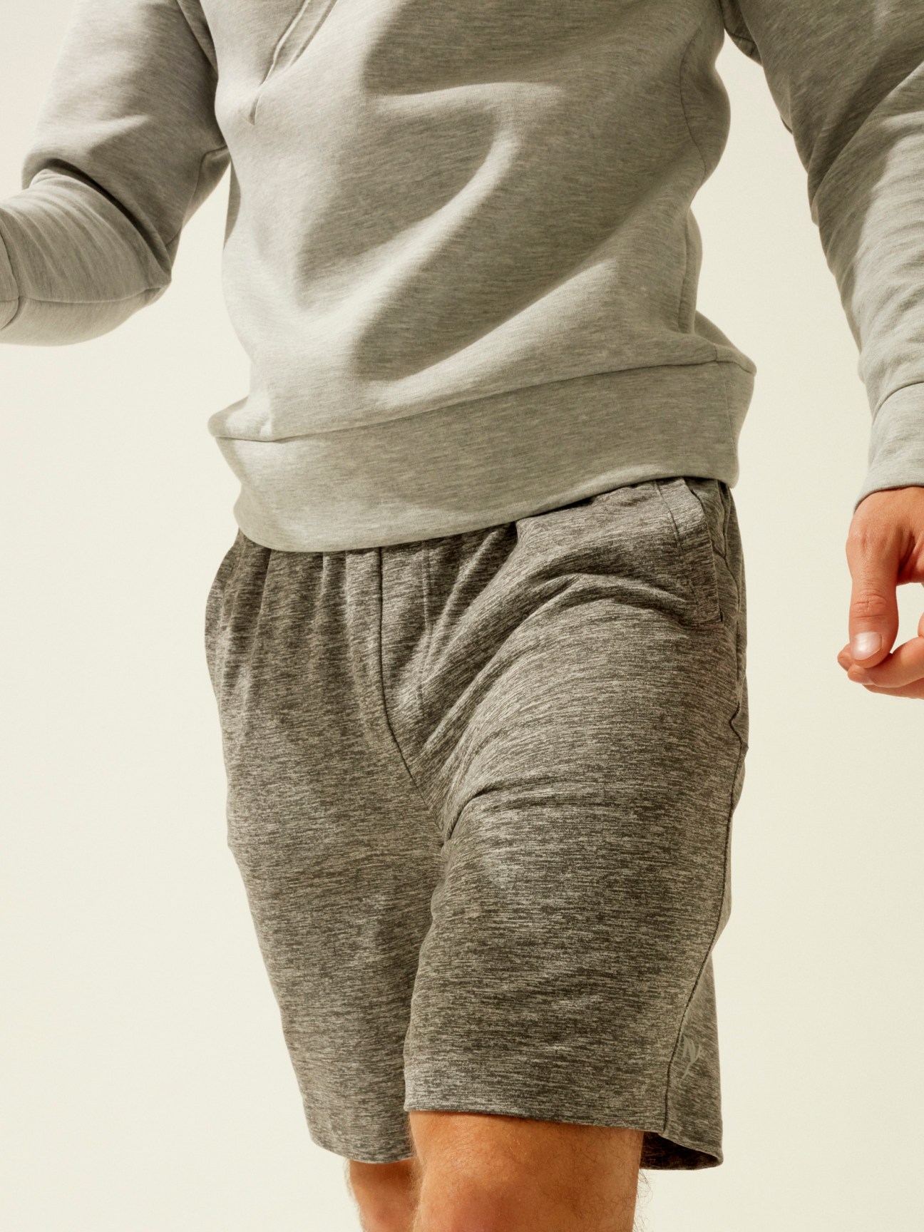 Male model wearing LNDR grey seamless leggings and matching long-sleeve athletic top.