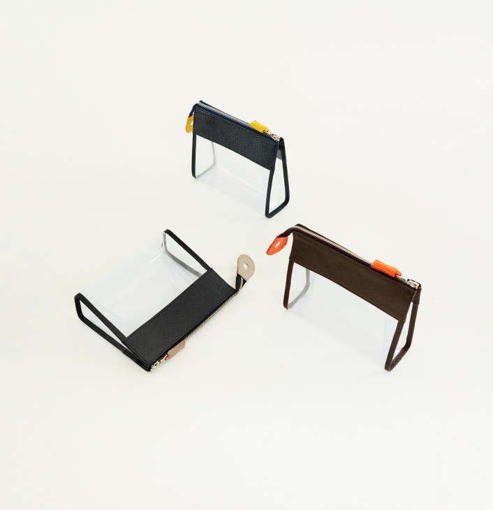 Three see-through travel toiletry pouches by R Horn's 3 Monocle in black, white, and brown with colored zipper pulls.