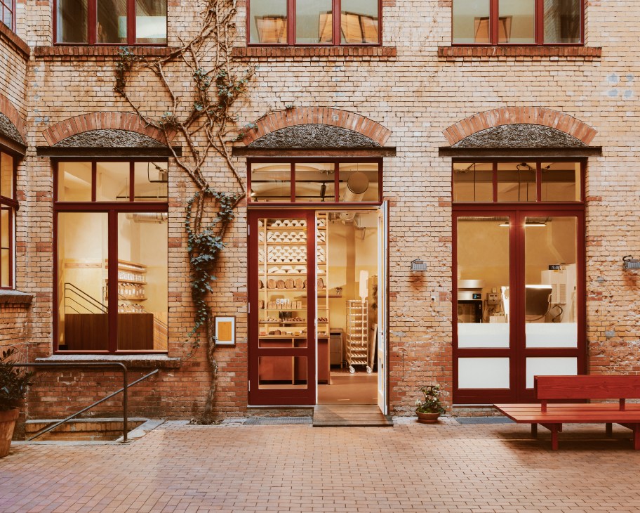 Exterior of Sofi bakery in Berlin showing brick building with red-framed windows and open storefront