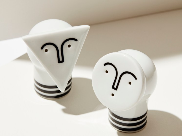 White ceramic salt and pepper shakers shaped like lightbulbs with simple face designs