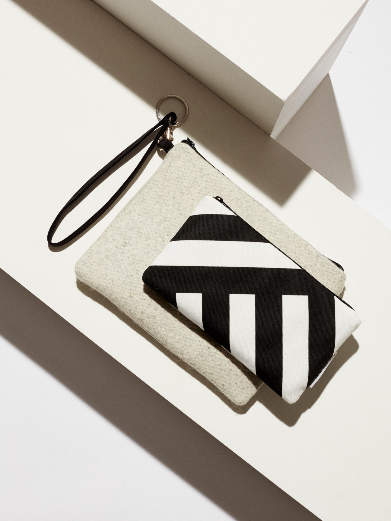 White felt pouches with black geometric patterns and leather wrist straps from Said the Fox
