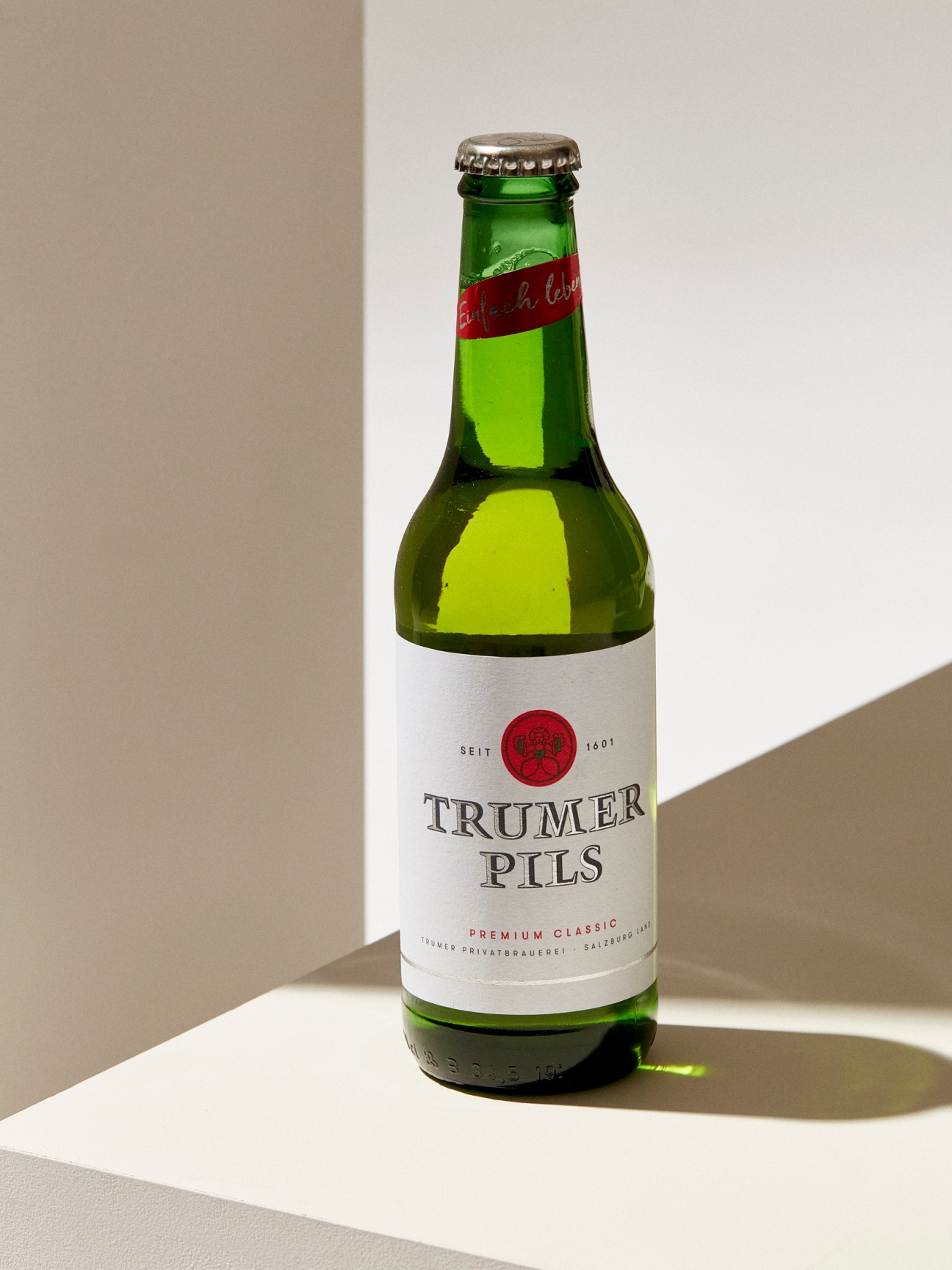 Trumer Pils pilsner beer bottle in green glass with white label and silver cap