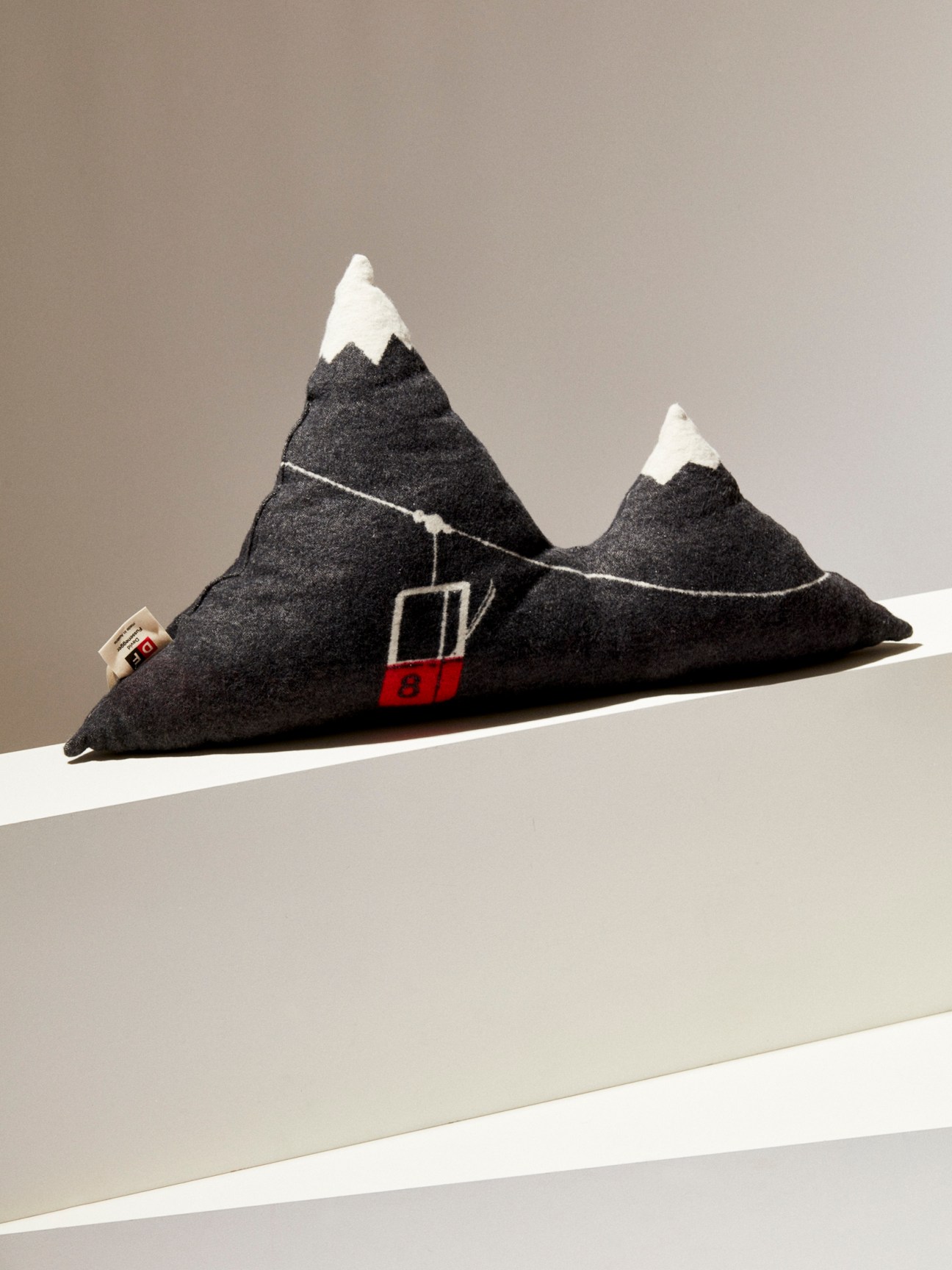 Mountain-shaped cushion with cable car design by David Fussenegger