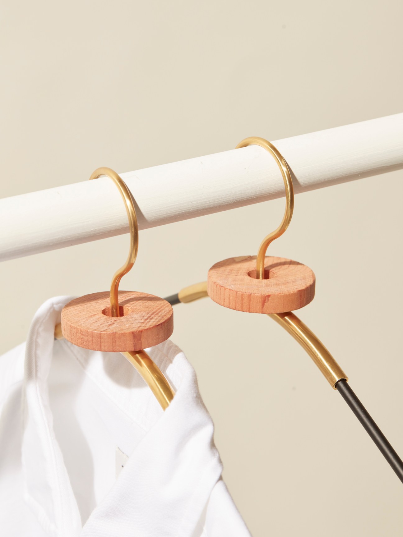 Cedar rings from Iris Hantverk and Menu coat hanger hanging on white closet rod with white shirt