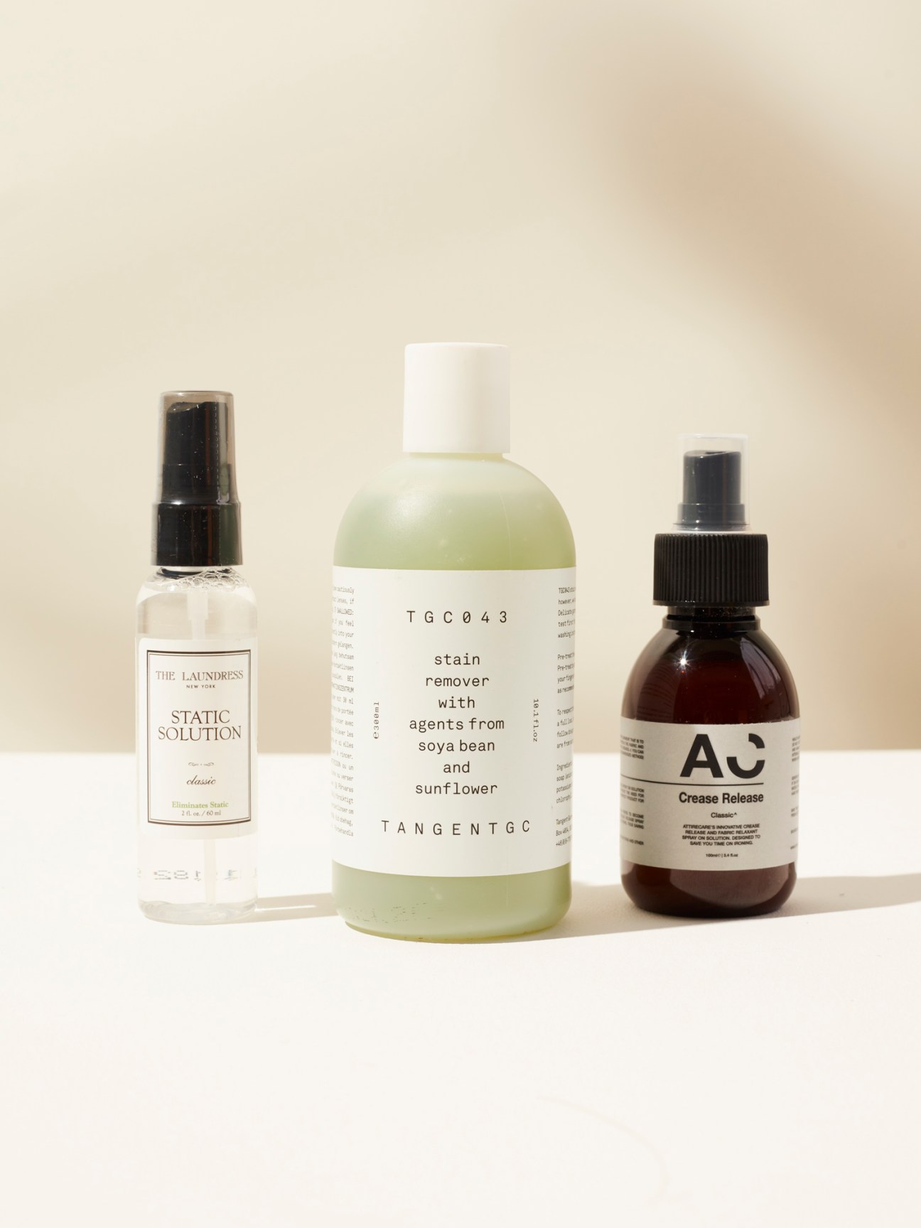 Three laundry care products including The Laundress static solution, TangentGC stain remover, and Attirecare crease release
