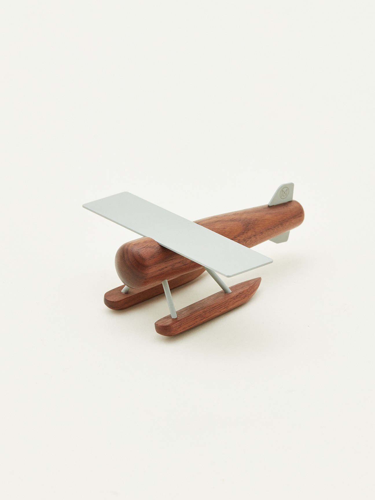 Wooden seaplane toy with white wings and metal accents by Mad Lab x Monocle.