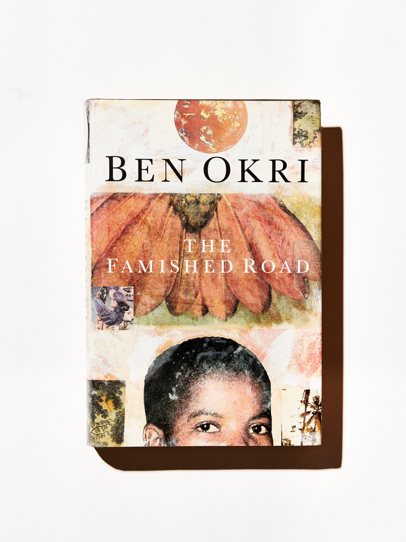 The Famished Road book cover by Ben Okri featuring artistic collage design with circular motifs and portrait