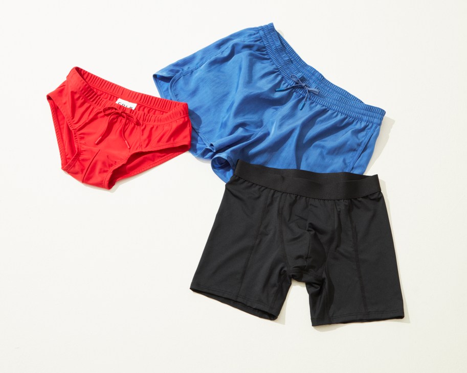 Three pairs of colorful swim and performance briefs in red, blue, and black by CDLP.