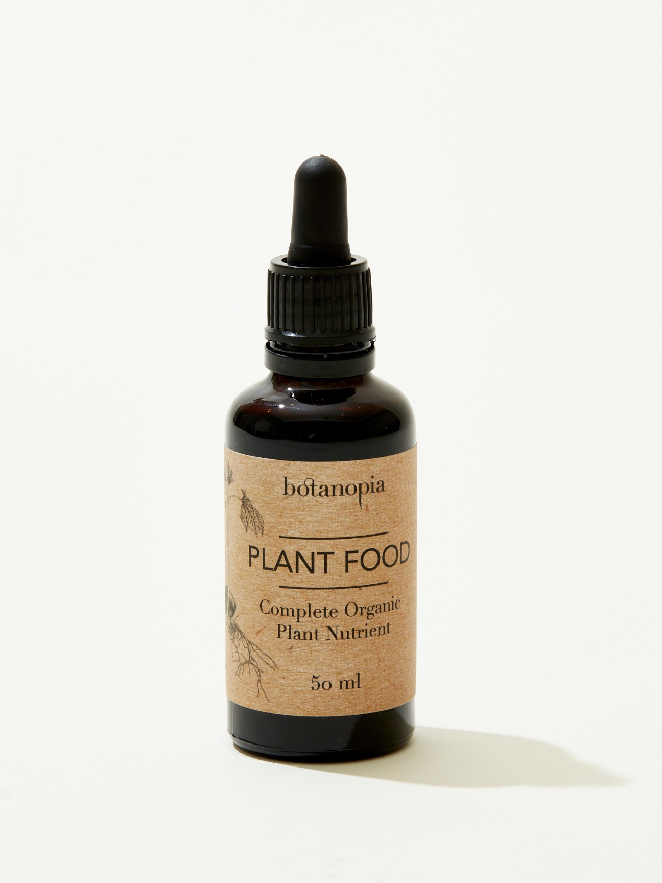 Dark glass dropper bottle with kraft paper label reading Botanopia Plant Food Complete Organic Plant Nutrient 50ml