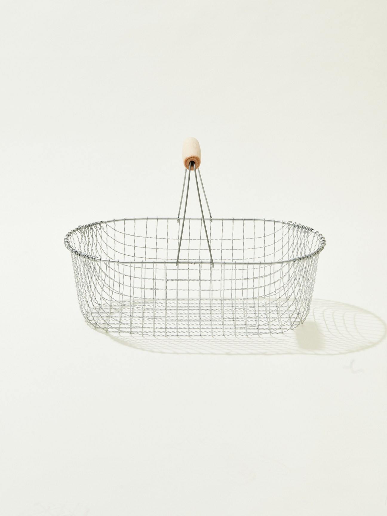 Wire mesh basket with wooden handle for carrying garden produce