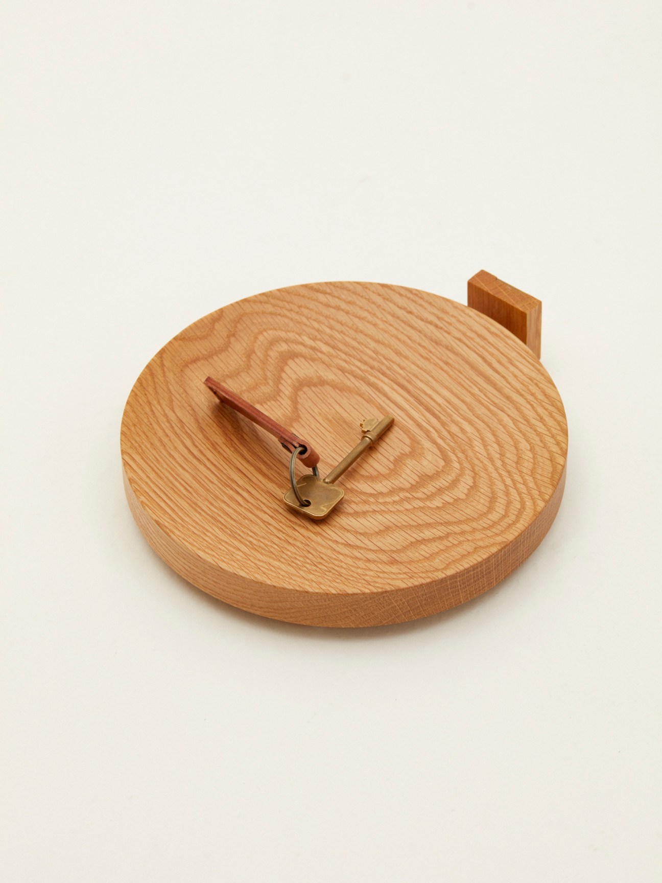 Wooden oak wall-mounted key tray with brass hook and wooden handle by Mad Lab x Monocle.