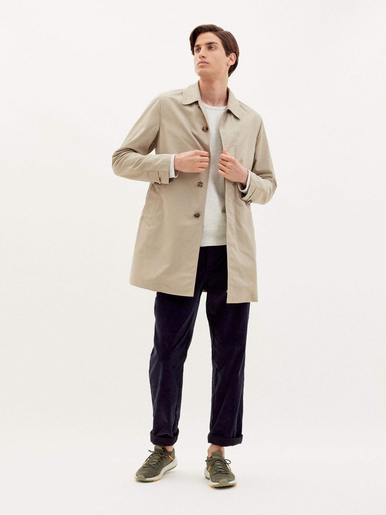 Man wearing beige Valstar x Monocle unlined mac coat over white shirt and dark trousers against neutral background