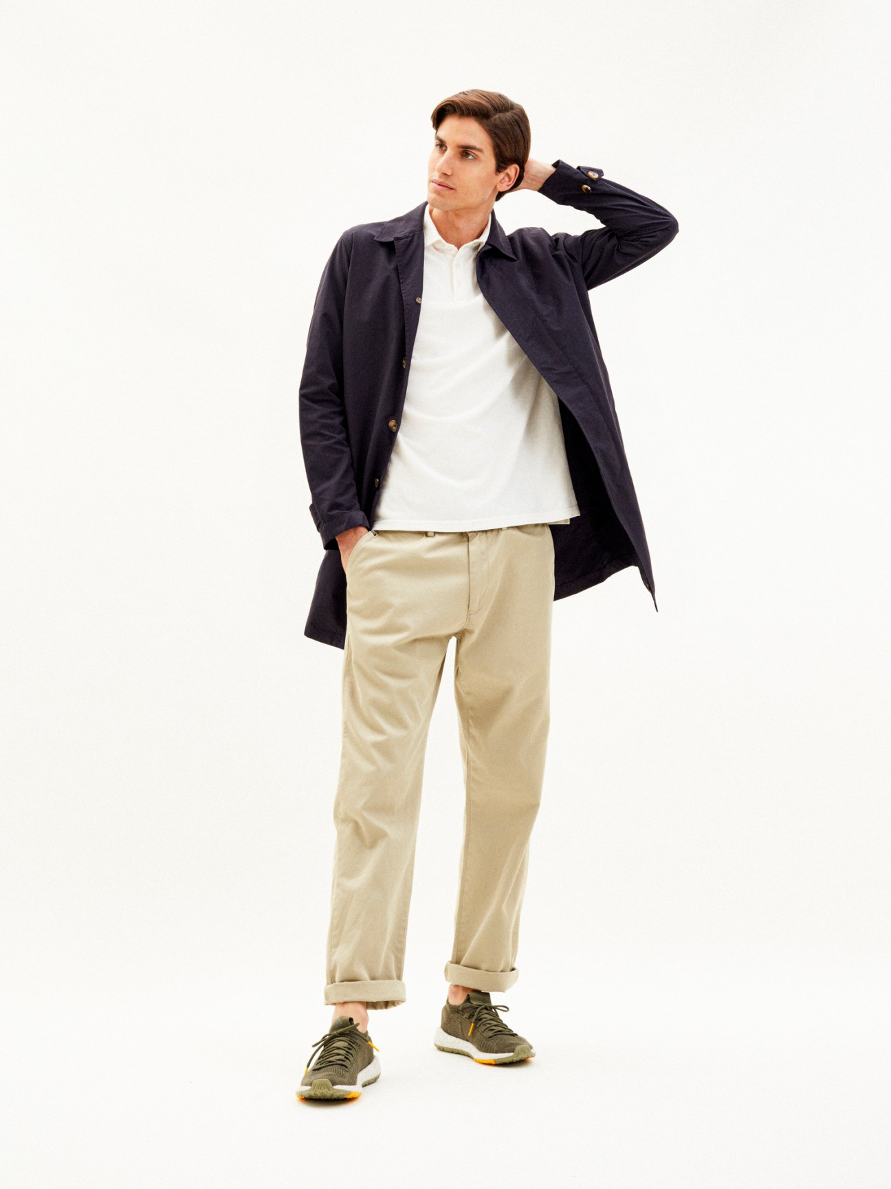 Man wearing navy Valstar unlined mac coat over white shirt and beige trousers with olive sneakers
