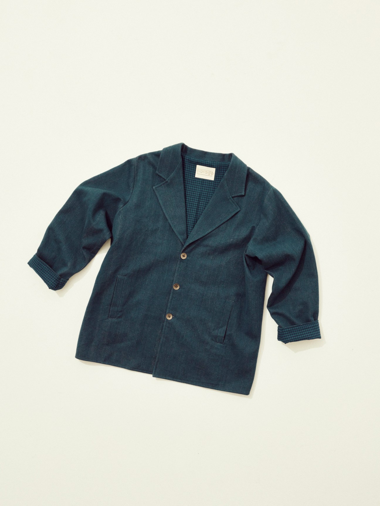 Dark teal button-up jacket with notched lapels and front pockets displayed on light background