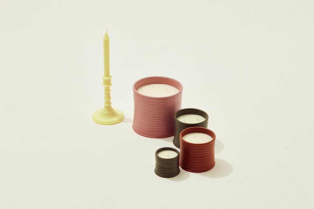 Loewe home fragrance collection with terracotta candles and yellow candlestick on neutral background
