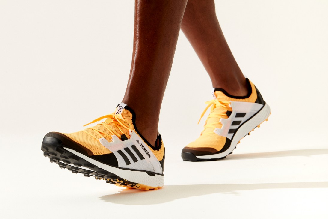 Speed LD trail running shoe by Adidas Terrex in yellow and white colorway worn on legs in motion
