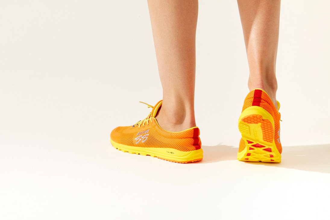 Person wearing Boulder trainer by Active 88 in orange and yellow colorway on legs against neutral background
