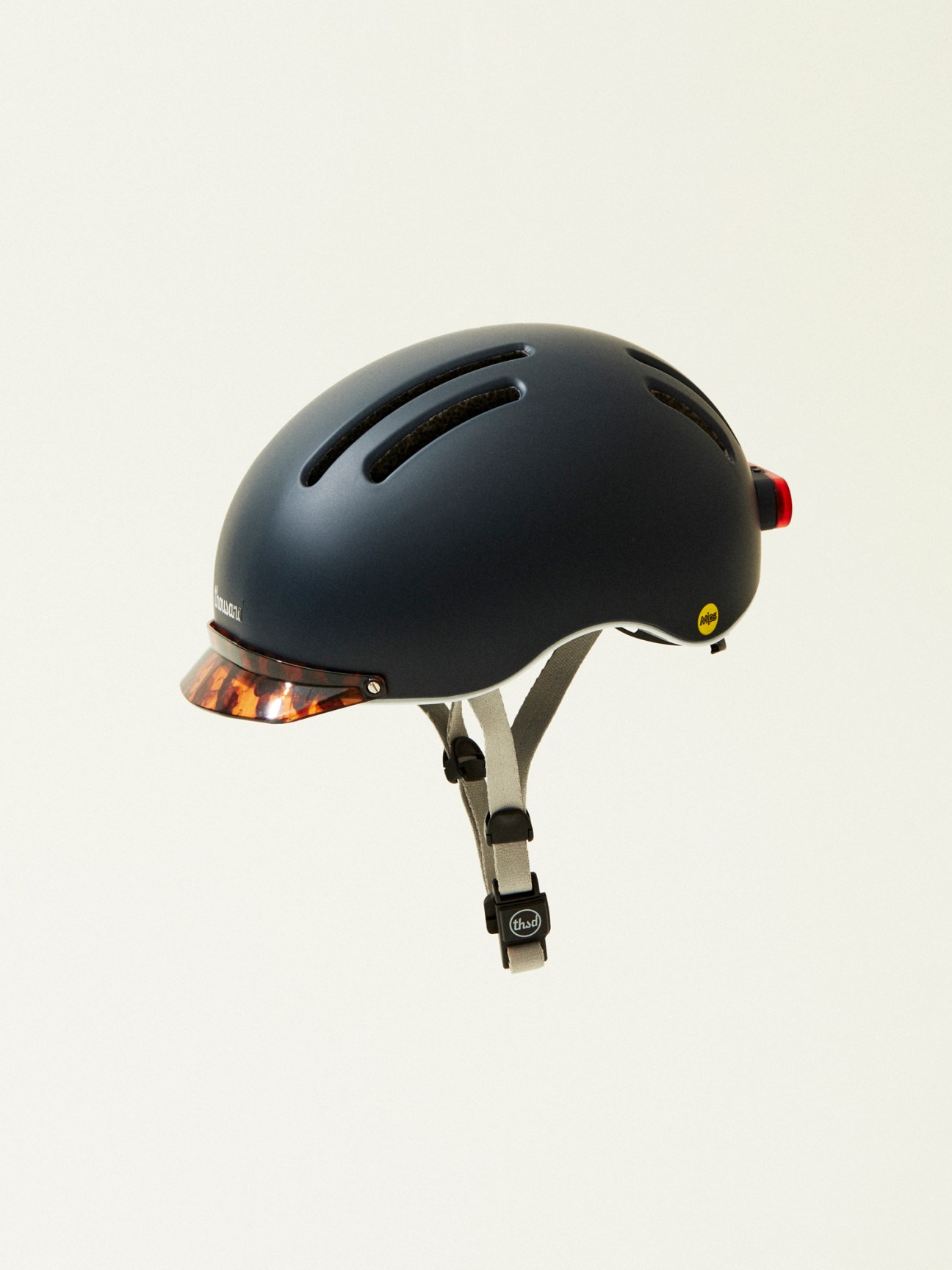 White bike helmet with ventilation holes and tortoiseshell visor on white background