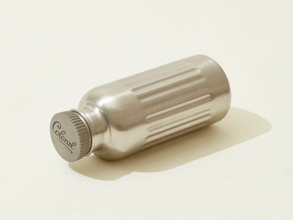 Champagne colored metallic water bottle with ridged design and Coloral branded cap on white background