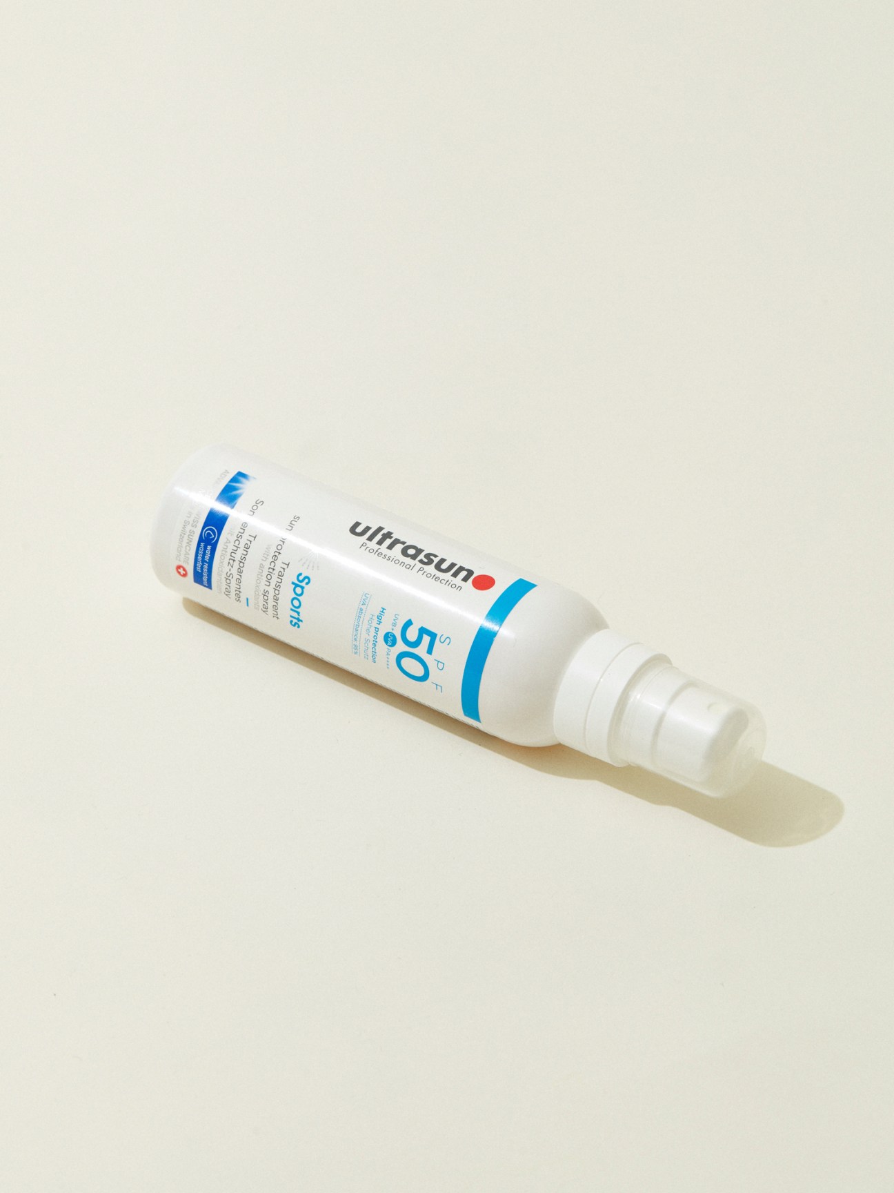 White Ultrasun sunscreen tube with blue accents lying on white background