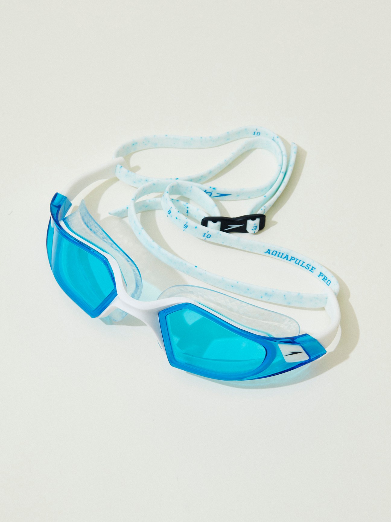 Blue and white Speedo Aquapulse Pro swimming goggles with adjustable strap on white background