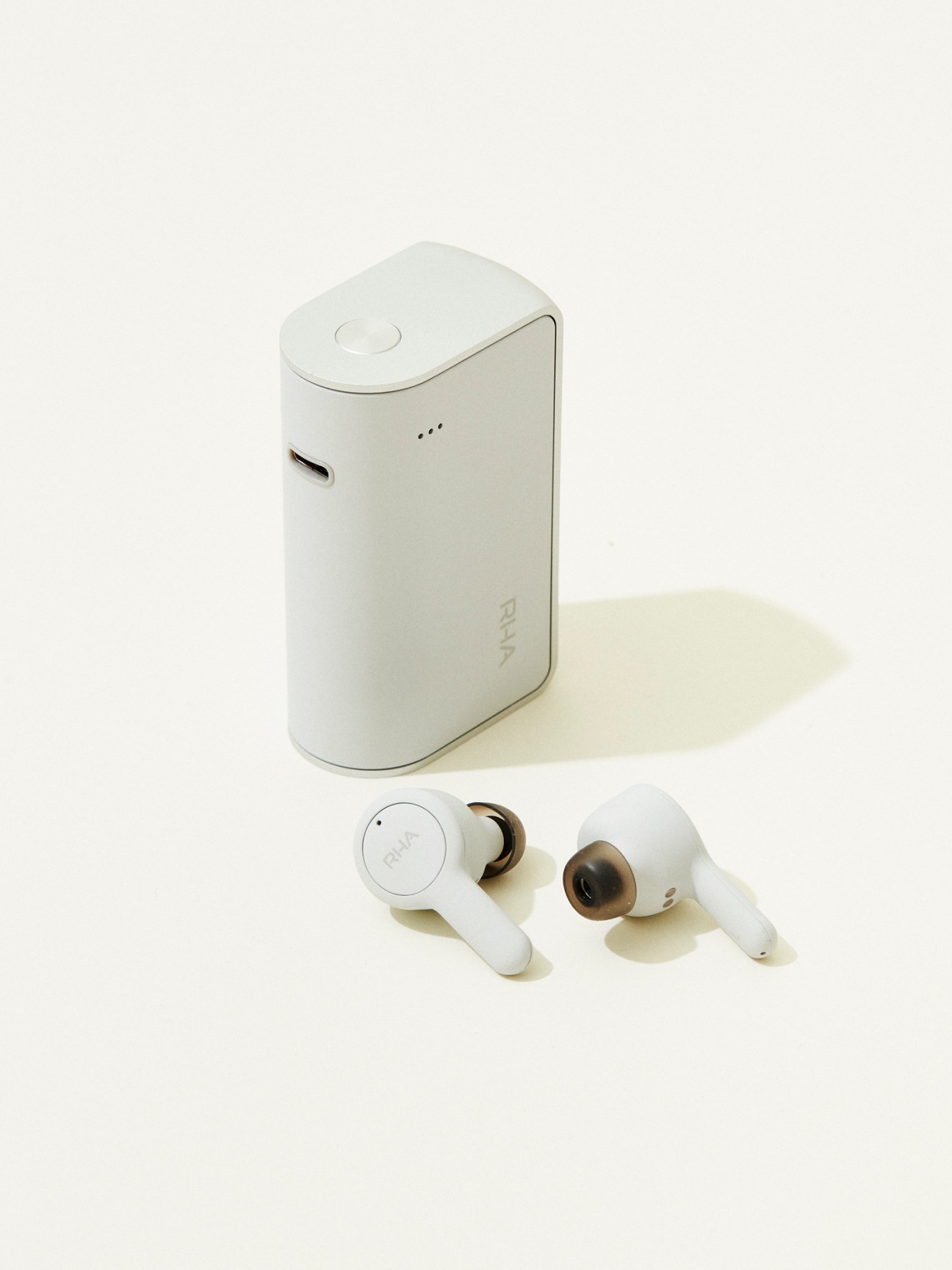 White wireless earbuds with charging case on white background