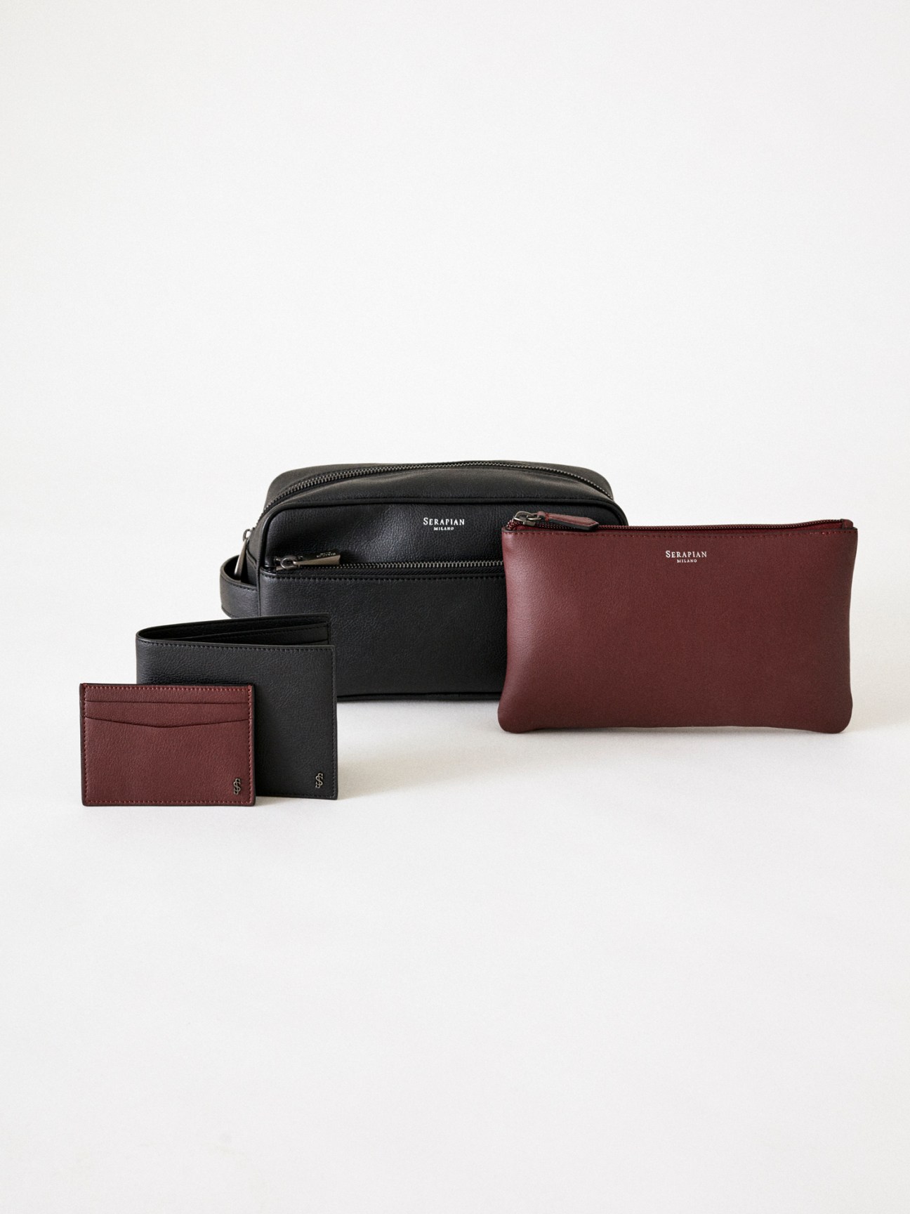 Serapian leather goods collection featuring black and burgundy bags, pouches and card holders