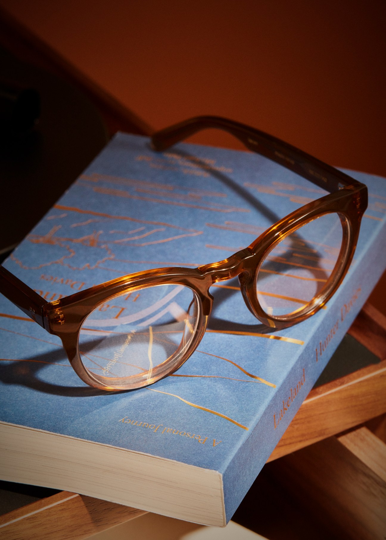 Reading glasses and book positioned on bedside table