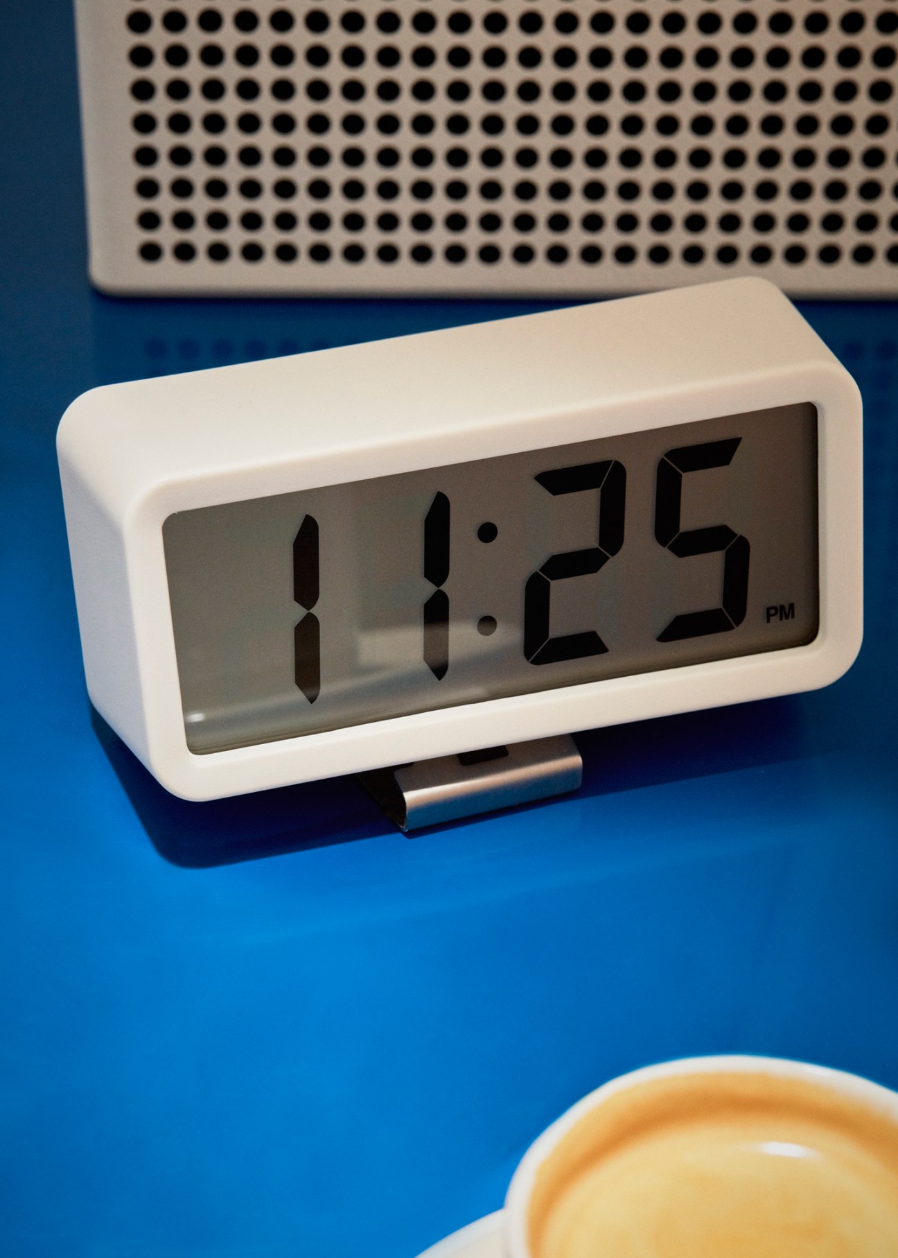 White digital clock displaying 11:25 PM on blue surface