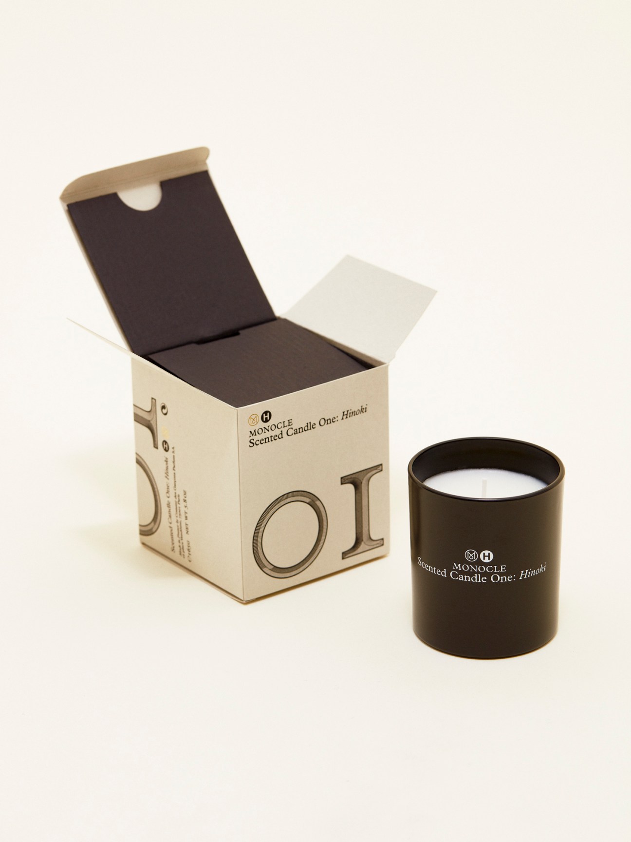 Comme des Garçons x Monocle Candle One: Hinoki with cream packaging box and black cylindrical container.