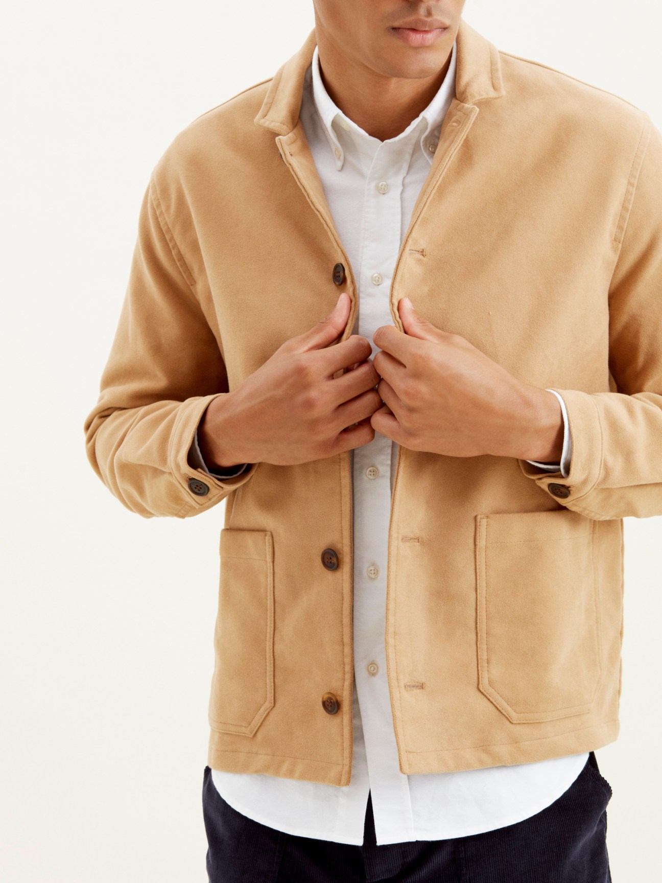 Man wearing beige moleskin jacket with button front closure and chest pockets
