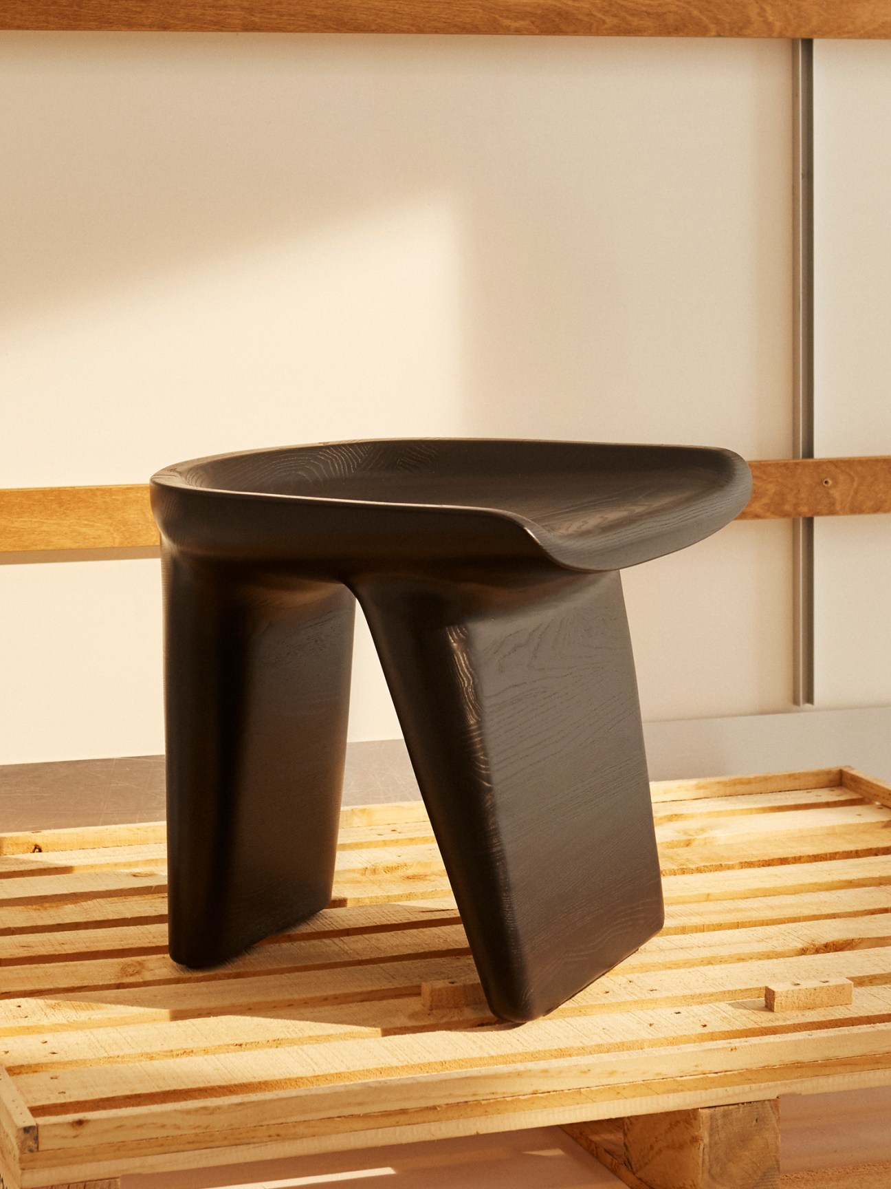 Black-stained ash Monolog stool by Ligne Roset with curved organic form and two wide supporting legs