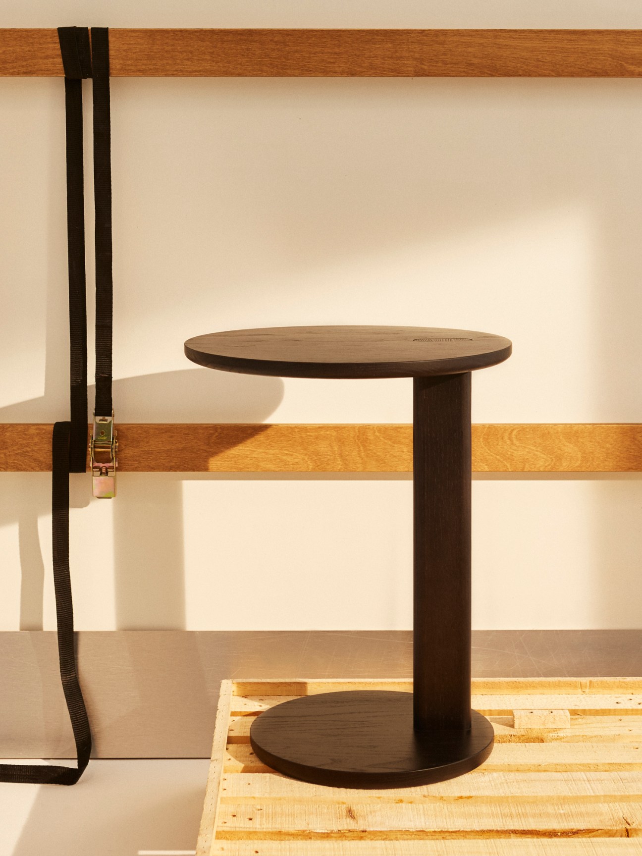 Elephant side table made from Japanese chestnut wood with asymmetrical leg design positioned next to upholstered furniture