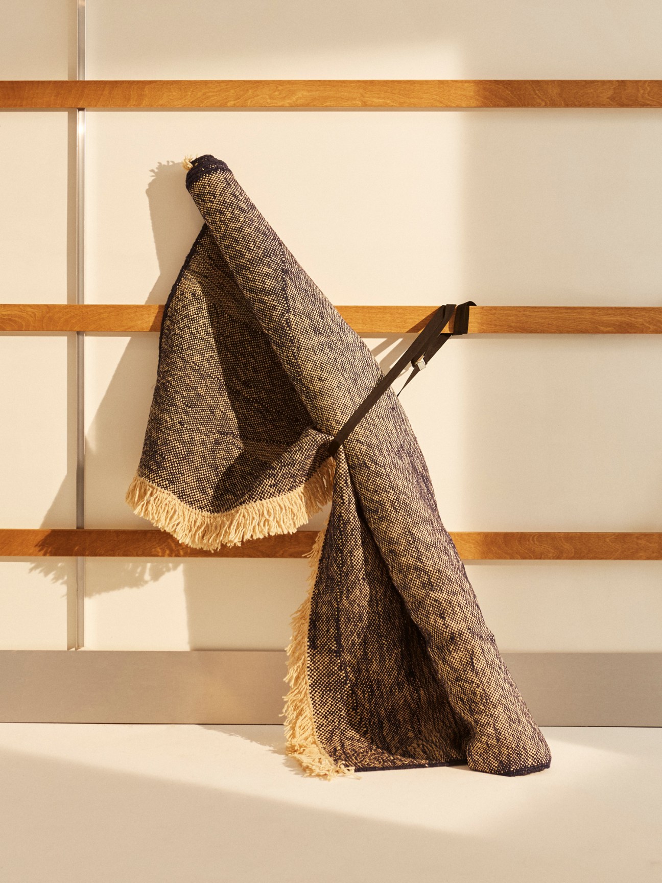 Telares rug with woven geometric patterns and fringed edges draped over wooden steps