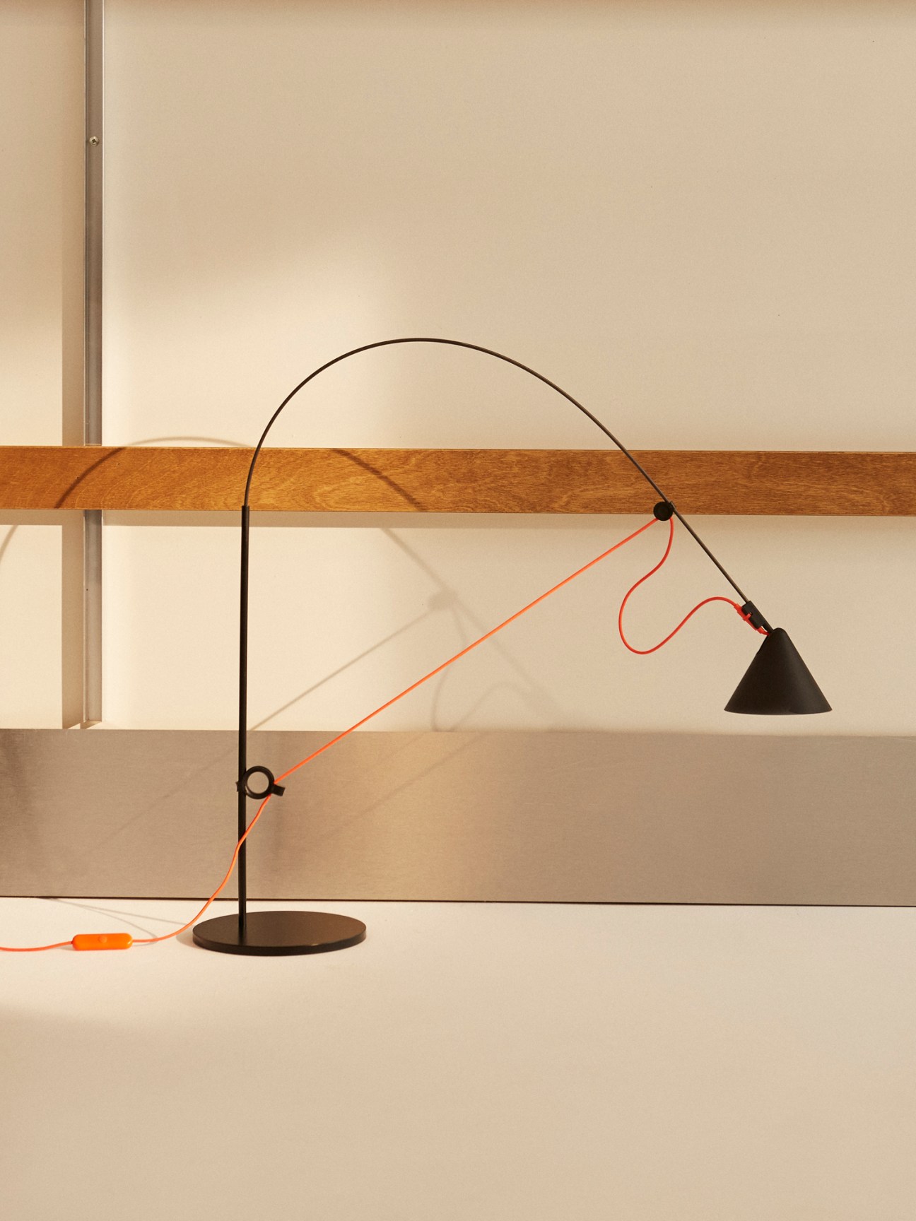 Black Ayno table lamp by Midgard with curved arched design and conical shade on round base