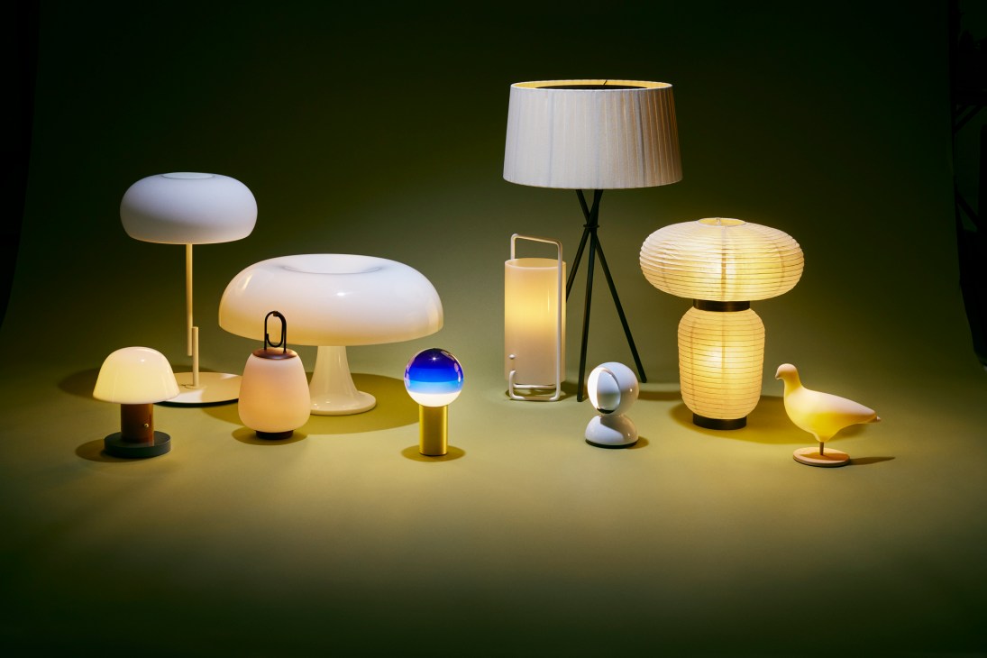 Collection of modern designer table lamps and lighting fixtures illuminated against dark background