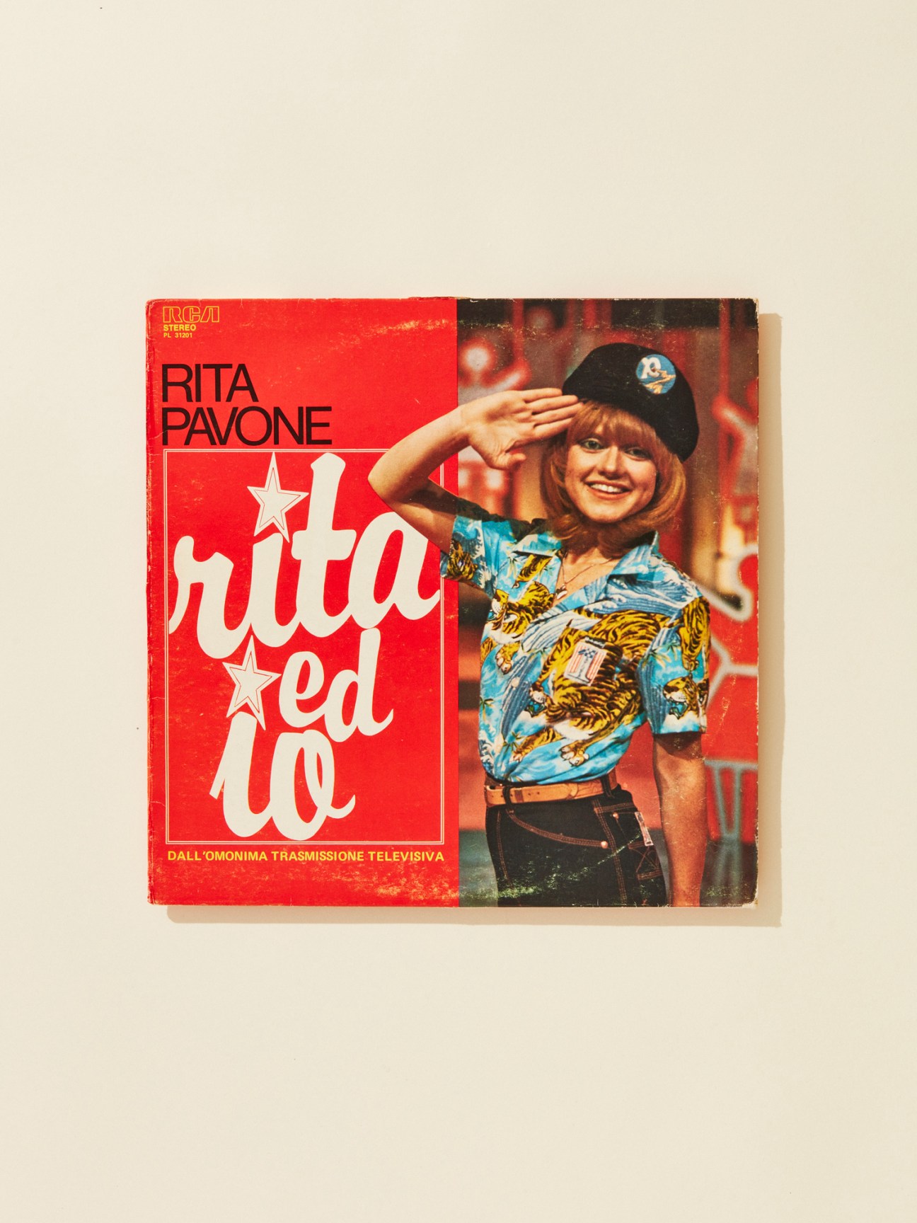 Rita Pavone album cover for 'Rita ed io' from 1977 featuring the singer in a patterned blue shirt and black cap.