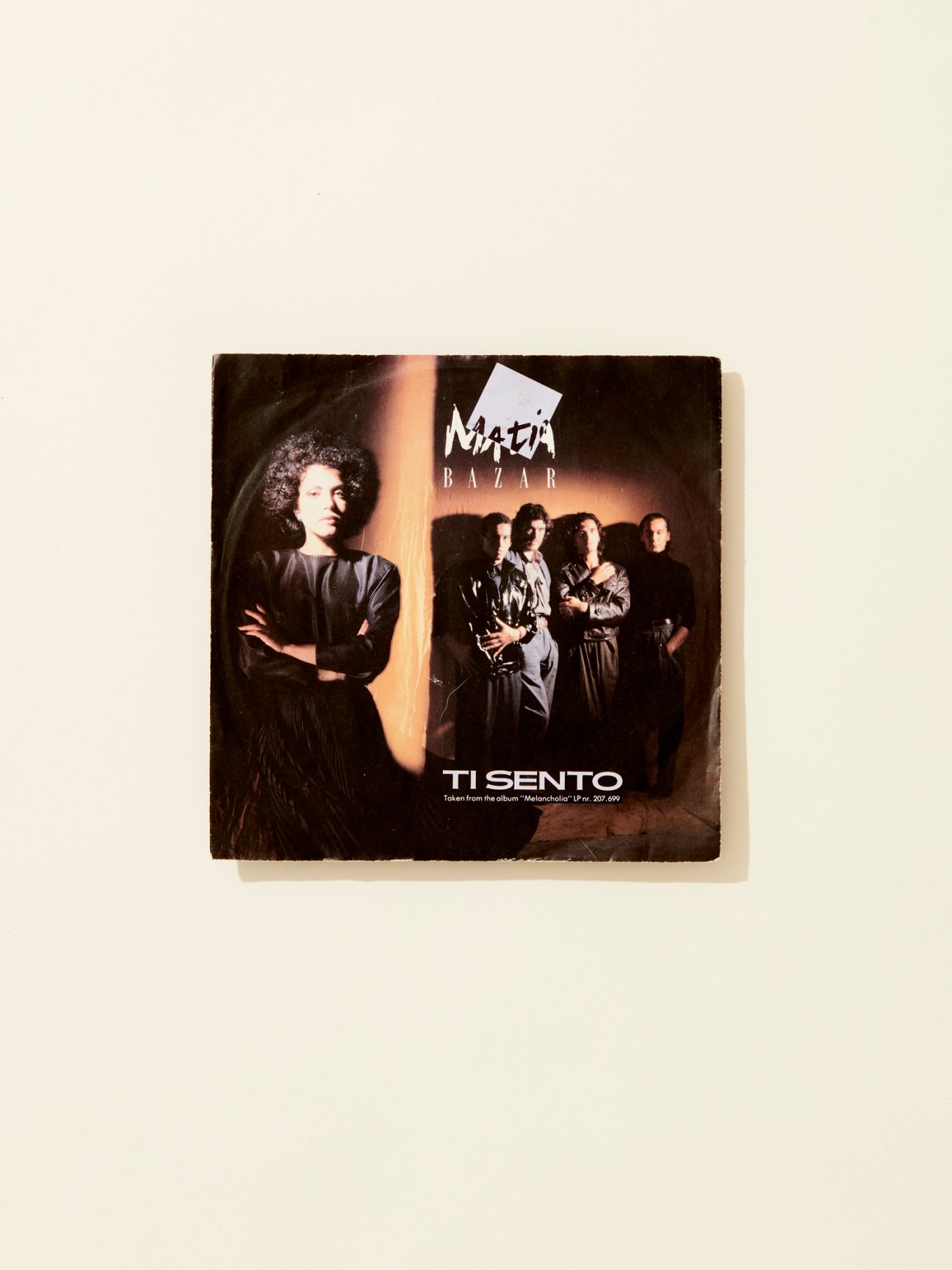 Album cover for Matia Bazar's 1 (1976) featuring band members in dark lighting against cream background.