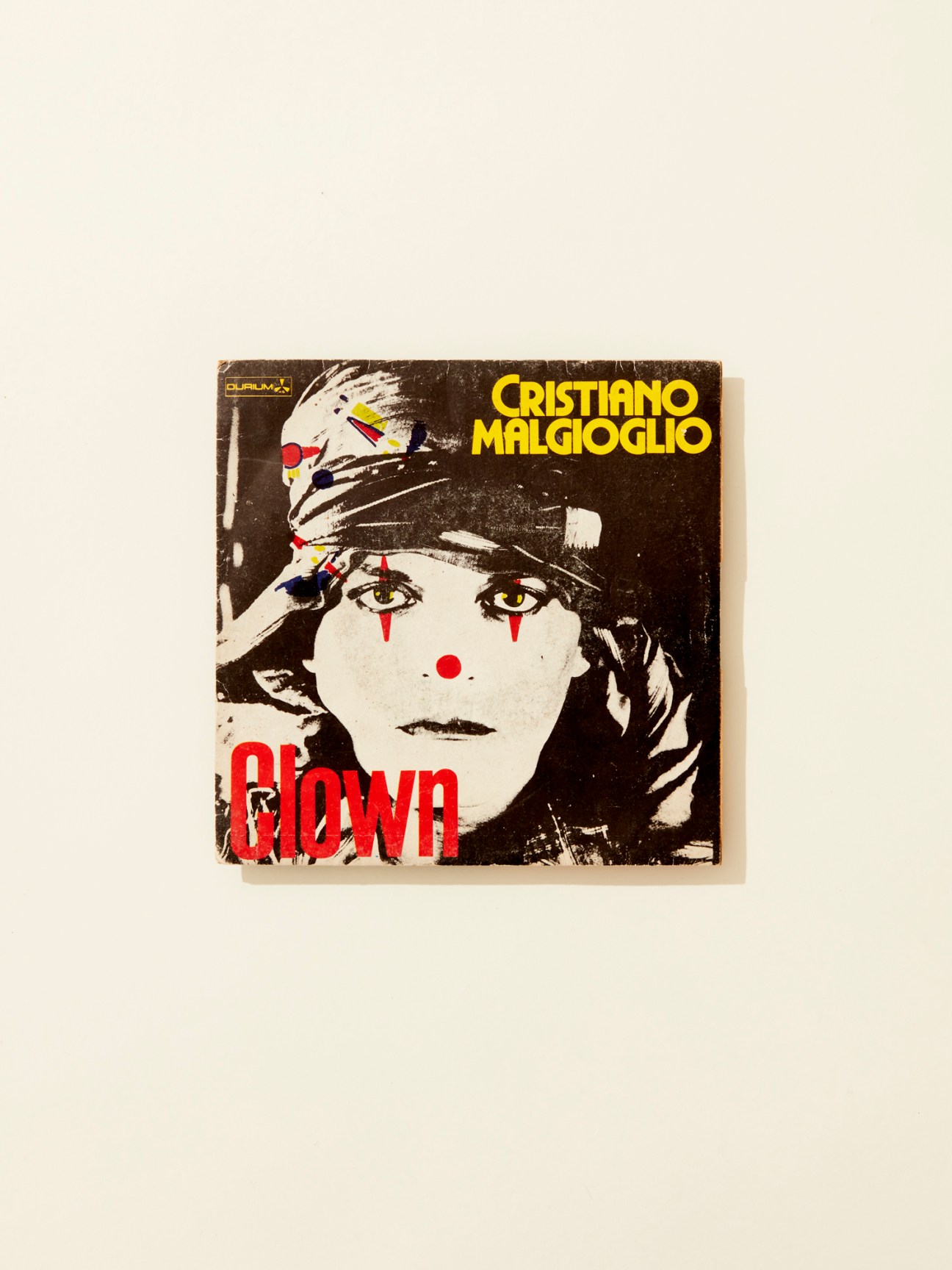Vintage vinyl record cover for Cristiano Malgioglio's 'Clown' (1982) featuring a stylized clown face with dramatic makeup in black, white and red.