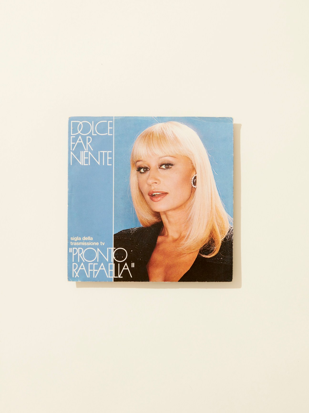 Raffaella Carrà album cover for Dolce Far Niente featuring the Italian singer with platinum blonde hair against a blue background.